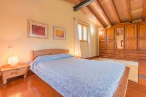 sypialnia z niebieskim łóżkiem i drewnianym sufitem w obiekcie Villa Luisa by Sealand Villas w mieście Crestatx +10 zdjęć