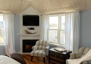 a living room with two chairs and a fireplace at Beach Street Inn in St. Martins