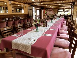 una fila de mesas en un restaurante con mantel rosa en Hotel Merdjan, en Sarnitsa