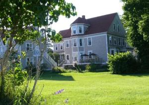 a large house with a large yard with green grass at Beach Street Inn in St. Martins