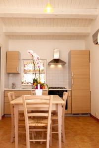 a kitchen with a wooden table and chairs and a kitchen with a stove at Azienda Agrituristica e Didattica CrauNari in Modica