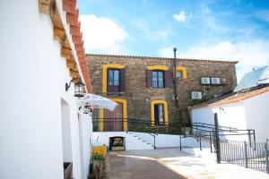 um grande edifício de tijolos com portas e janelas amarelas em La Casa Grande de Adolfo em La Codosera