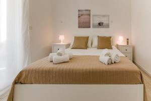 a bedroom with a large bed with towels on it at MAGNOLIA - ORTI'S PLACE in Alghero
