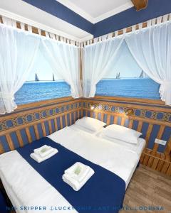 a bedroom with a bed with a view of the ocean at Lucky Ship Art Hotel in Odesa