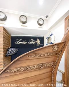 a staircase in a hotel with clocks on the wall at Lucky Ship Art Hotel in Odesa