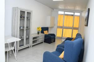 sala de estar con sillas azules y armario en Casa Teresita, en Deltebre