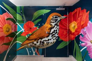 a painting of a bird on a wall with flowers at Hotel Madera in Washington, D.C.