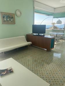 sala de estar con TV y sofá en Grande Attico con Vista Vicino al Centro by PortofinoVacanze, en Rapallo