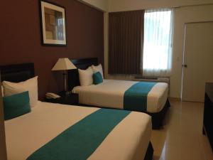 a hotel room with two beds and a window at Hotel Las Vegas in Poza Rica de Hidalgo