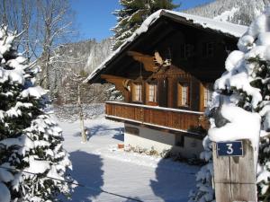 Una cabaña en la nieve con un cartel. en Chalet Nyati, en Gstaad