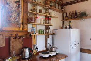 cocina con nevera blanca y encimera en Cabaña La Linda - Complejo El Taller en Potrerillos