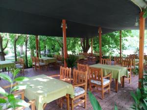 a restaurant with tables and chairs under a tent at Olympos Yavuz Hotel in Cıralı
