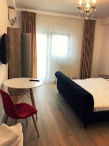 1 dormitorio con 1 cama, 1 mesa y 1 silla en M Rooms, en Bucarest