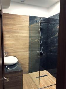 a bathroom with a glass shower with a sink at M Rooms in Bucharest