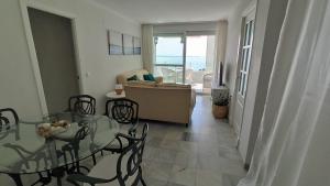 a living room with a glass table and chairs at Apartamento Sea Views Las Redes in El Puerto de Santa María