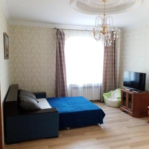 1 dormitorio con 1 cama azul y TV en Дача в Санжейке с уютной территорией для отдыха у Чёрного моря, en Sanzhiyka