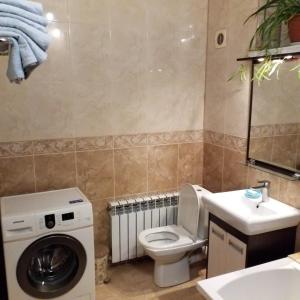 W łazience znajduje się toaleta, umywalka i pralka. w obiekcie Дача в Санжейке с уютной территорией для отдыха у Чёрного моря w mieście Sanżijka