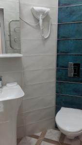 a bathroom with a toilet and a phone on the wall at In the heart of the city in Kharkiv