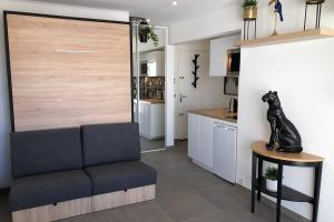 a living room with a couch and a kitchen at Appartement vue mer et port, refait a neuf pour vous ! Climatisé in La Grande-Motte