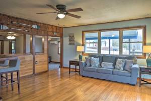 ein Wohnzimmer mit einem Sofa und einem Tisch in der Unterkunft Table Rock Lake House with Fire Pit Steps to Water! in Branson West