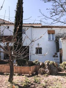 Biały dom z drzewem przed nim w obiekcie Alojamiento Rural El Gomis w mieście Confrides