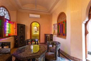 una camera con tavolo, sedie e vetrate istoriate di Riad Agdal Royal & Spa a Marrakech