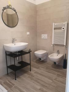 a bathroom with a sink and a toilet and a mirror at Battistelli Apartments in Bologna