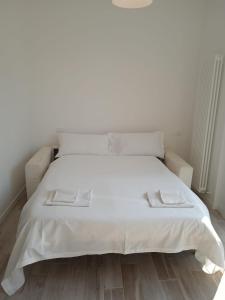 a white bed with two towels on top of it at Battistelli Apartments in Bologna