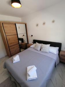 um quarto com uma cama grande e 2 toalhas brancas em Apartments Jakov em Makarska
