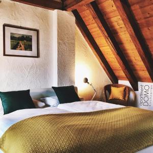 um quarto com uma cama num quarto com tectos em madeira em Apartment DOMO Kirchzarten em Kirchzarten