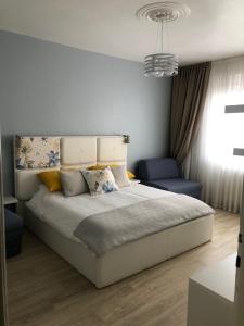 - une chambre avec un grand lit et une chaise bleue dans l'établissement Apartment Life Osijek, à Osijek