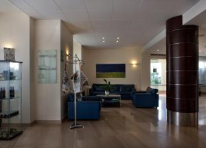 a living room with blue couches and a pole at Virgilio Grand Hotel in Sperlonga