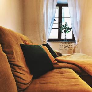 a couch with pillows on it in front of a window at Apartment DOMO Kirchzarten in Kirchzarten