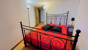 1 cama roja con almohadas negras en una habitación en Casa do Avô, en Sistelo