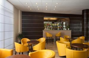 a restaurant with yellow chairs and tables and a bar at Virgilio Grand Hotel in Sperlonga