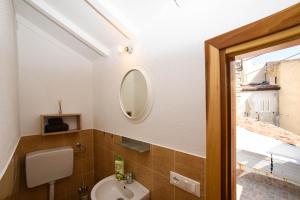 a bathroom with a sink and a toilet and a mirror at Casa Marta IUN Q1985 in Nuoro