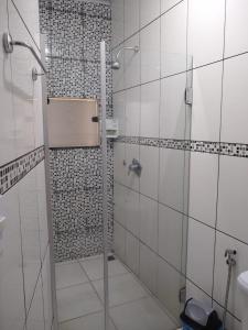 a shower with a glass door in a bathroom at Crystal Palace Hotel in Rolim de Moura