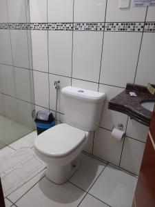 ein Badezimmer mit einem weißen WC und einem Waschbecken in der Unterkunft Crystal Palace Hotel in Rolim de Moura
