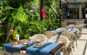 Temple Miletos Spa Hotel في ديديم: صف طاولات عليها اطباق طعام