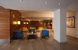 a lobby with blue chairs and a table at Virgilio Grand Hotel in Sperlonga