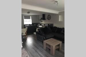 a living room with a couch and a table at 3 Story House near Bike park Wales & zip world in Aberaman