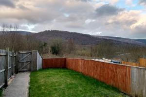 a fence in a yard with a mountain in the background at 3 Story House near Bike park Wales & zip world in Aberaman