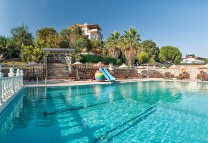 a swimming pool with a slide in the middle of it at Temple Beach Hotel in Didim