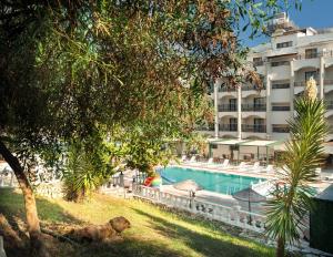 a swimming pool in front of a large building at Temple Beach Hotel in Didim