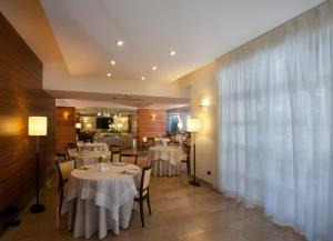 a restaurant with white tables and chairs and a window at Virgilio Grand Hotel in Sperlonga
