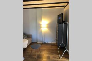 a living room with a television and a table at Studio de la porte de Samois in Moret-sur-Loing