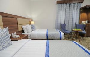 メディナにあるفندق دوما - Domma Hotelのベッド2台とテーブルと椅子があるホテルの部屋