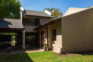 a white house with a porch and a patio at Il TRAMONTO in San Antonio de Areco