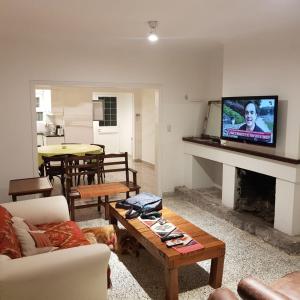 een woonkamer met een bank, een tafel en een tv bij Los Robles in Tandil