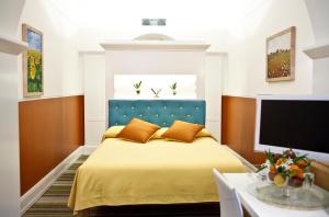 a bedroom with a bed with a blue headboard and a tv at Piazza Di Spagna Prestige in Rome +31 photos
